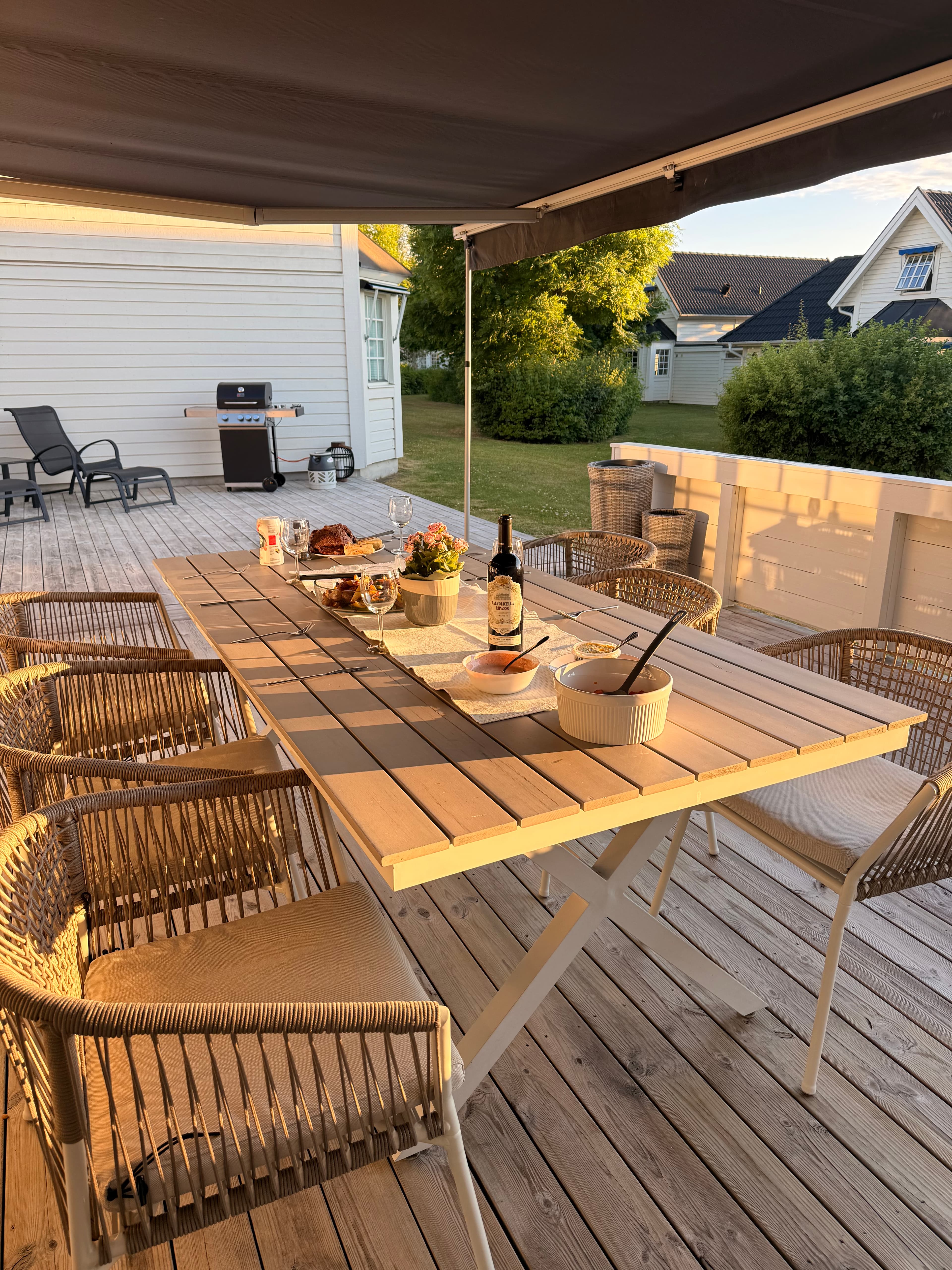 Matgrupp under markis, gasolgrill med platta